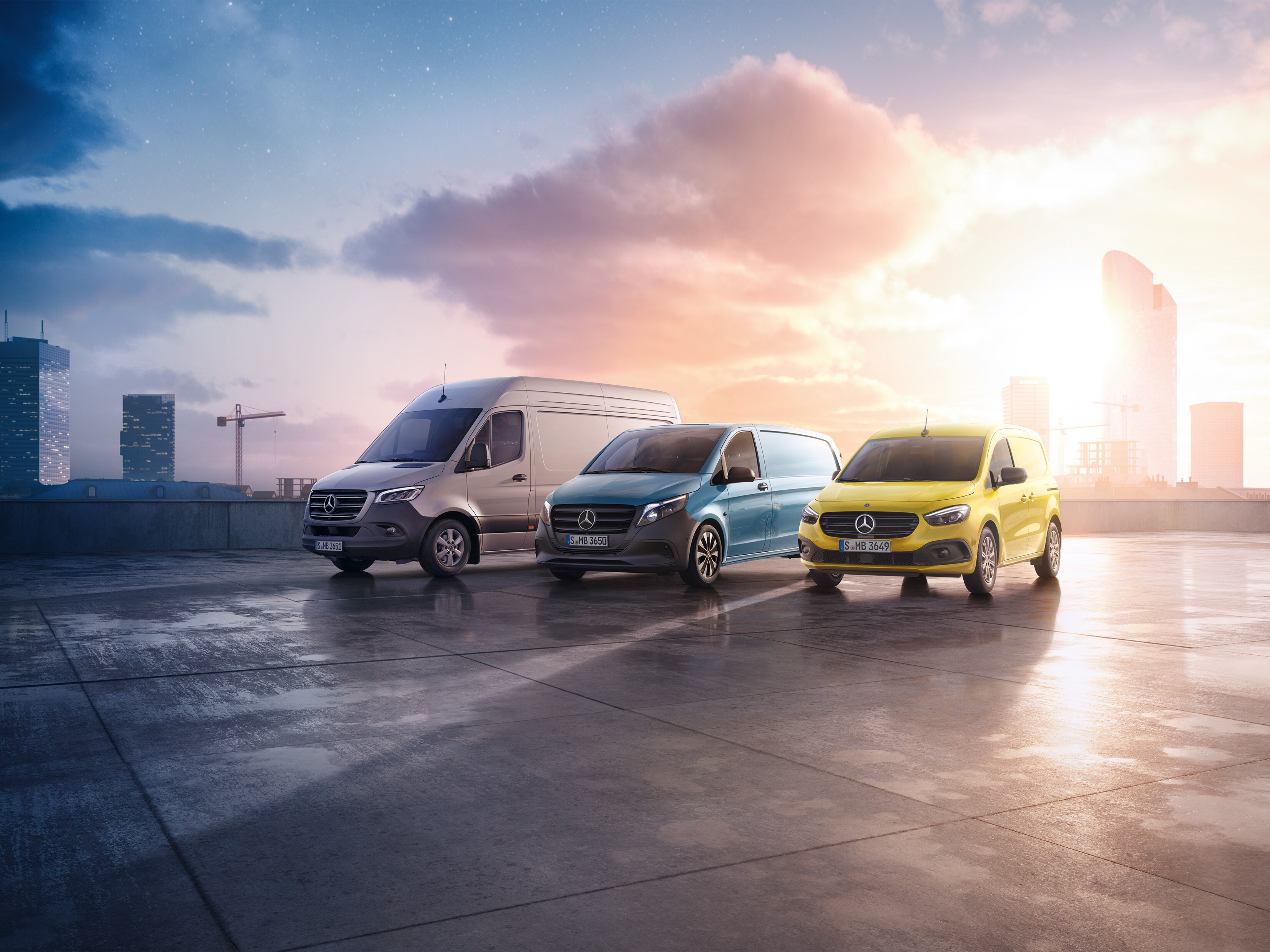 Drei Transporter von Mercedes-Benz Vans vor einer aufgehenden Sonne.