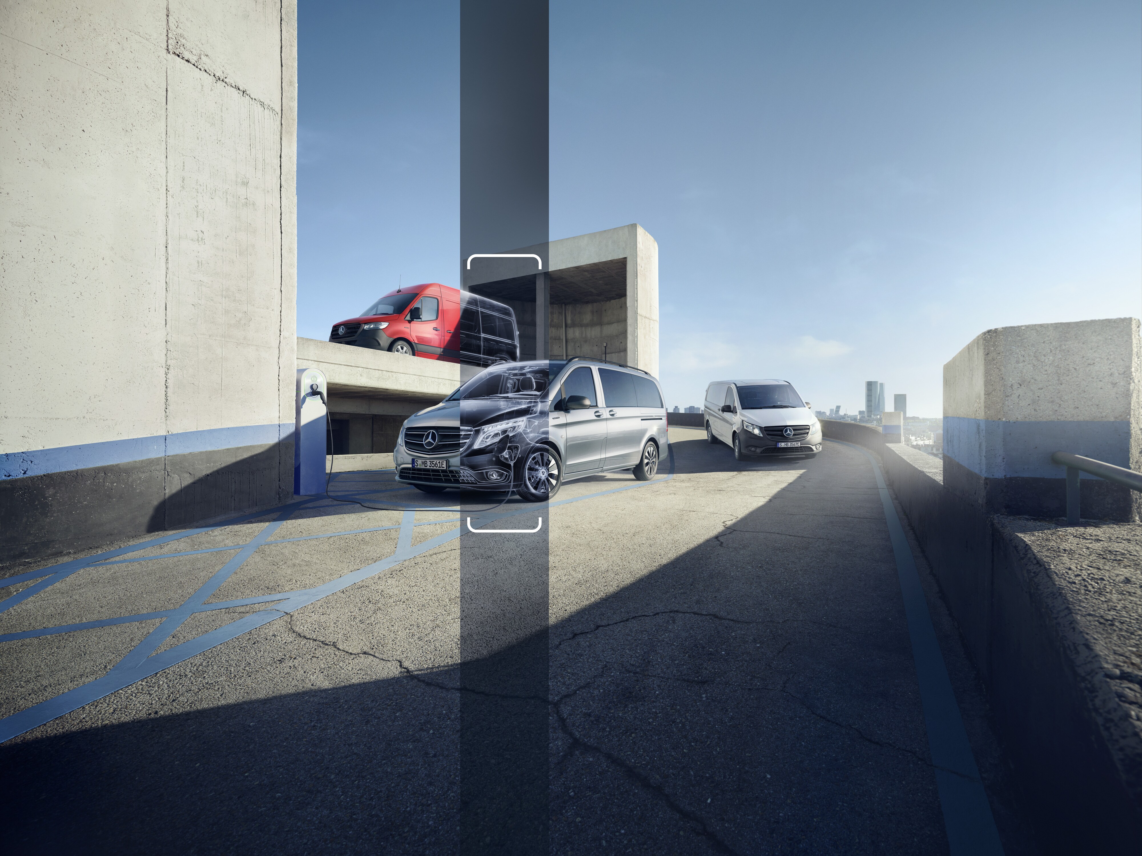 Drei Mercedes-Benz Transporter fahren eine Rampe in einem Parkhaus hoch.